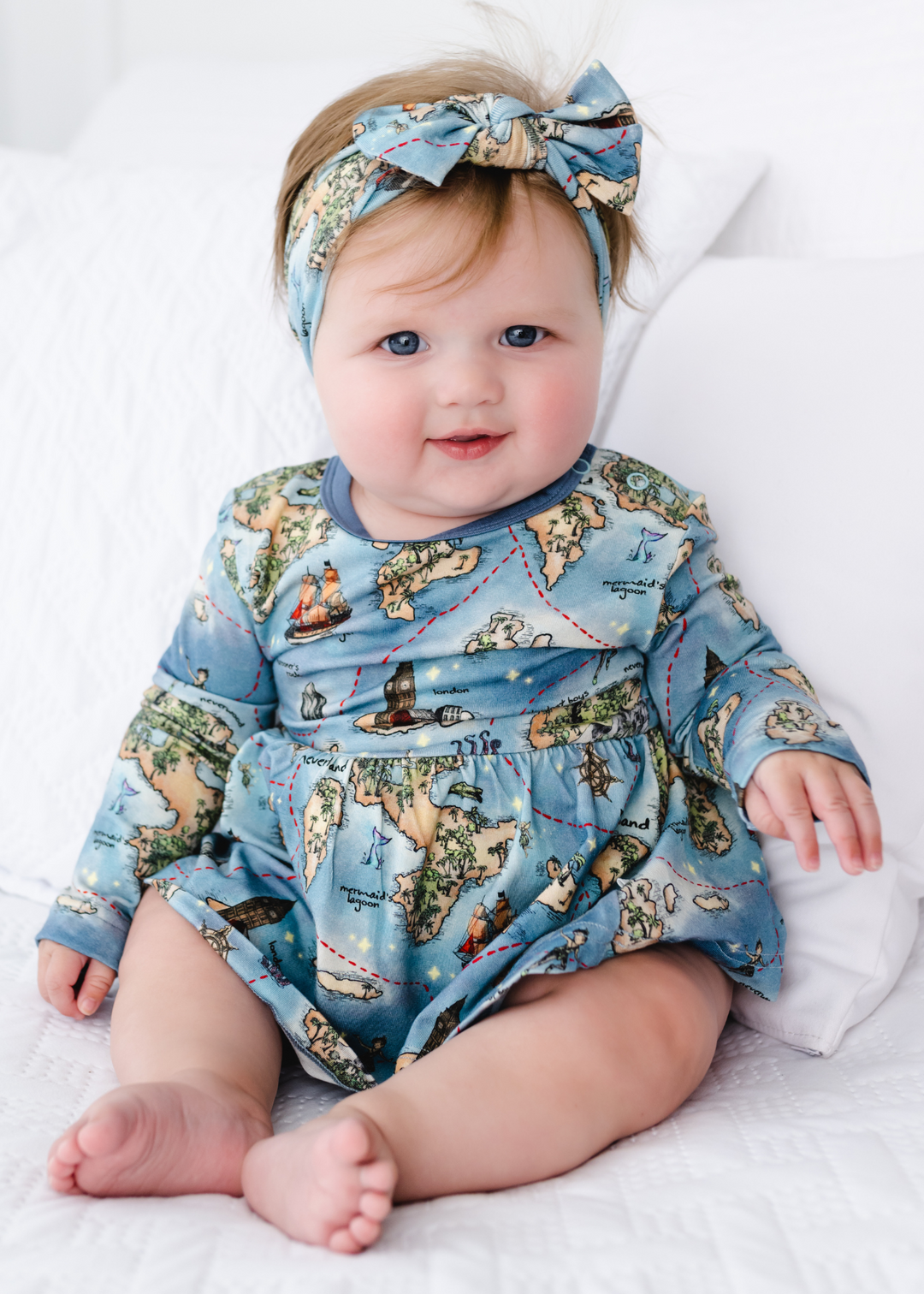 Neverland bamboo long sleeve baby dress model sitting up. Peter Pan Map bamboo long sleeve baby dress model sitting up.