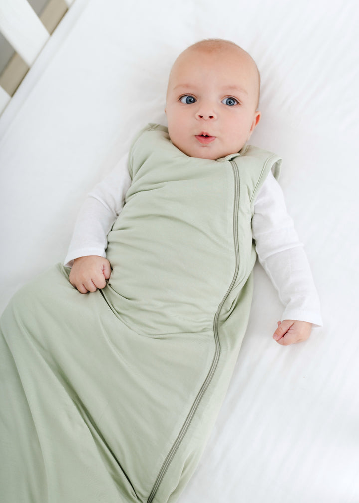 Hundred Acre Woods moss green sleep sack with baby. Winnie the Pooh map cuff color sleep sack with baby.