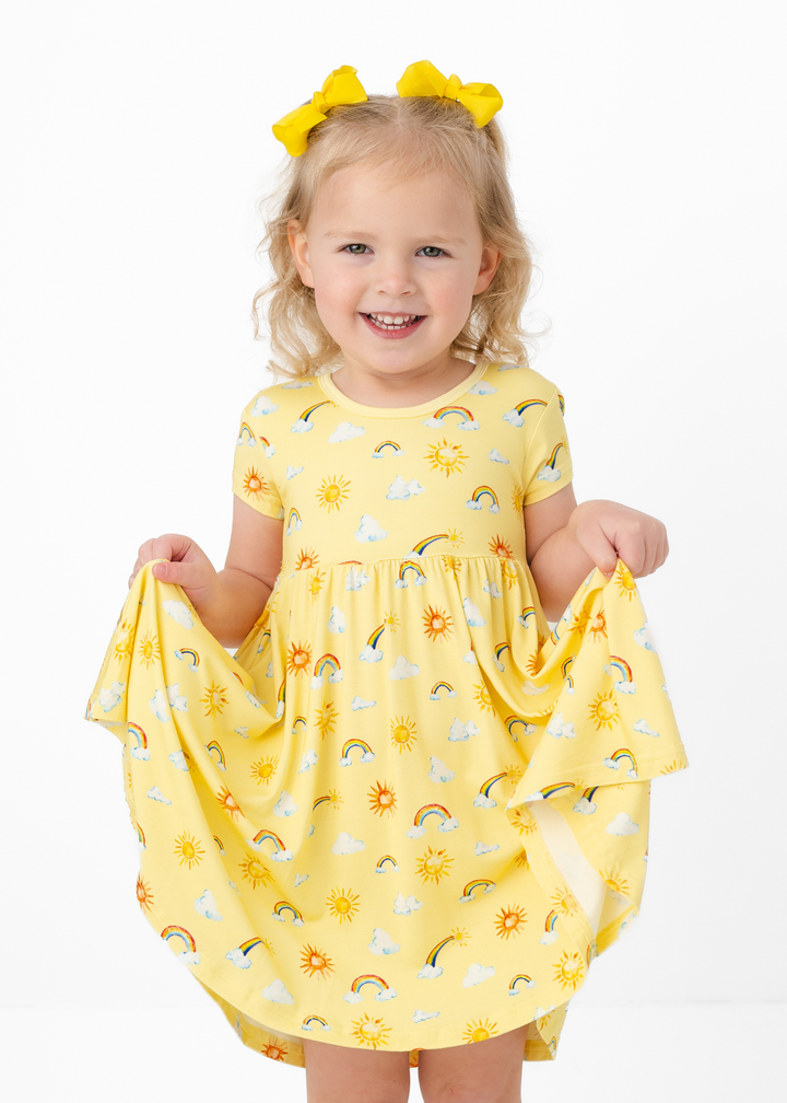 Girl wearing bamboo sunshine and rainbows yellow dress. This bamboo dress comes with bamboo shorts underneath.