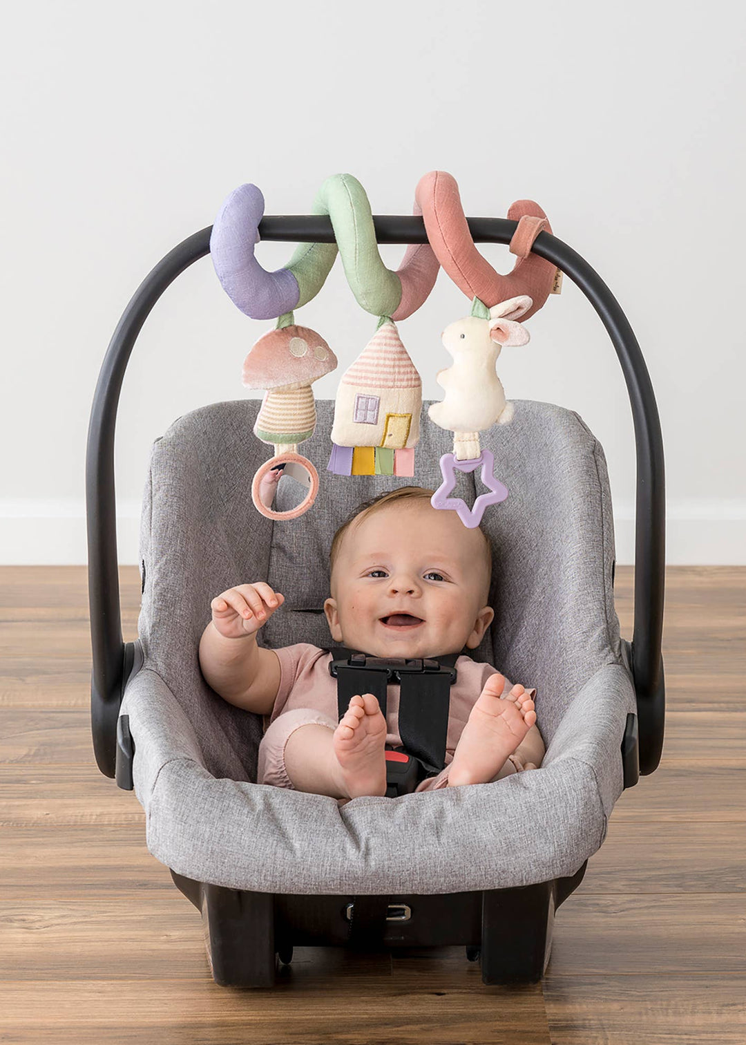 Baby in a car seat with colorful hanging toys