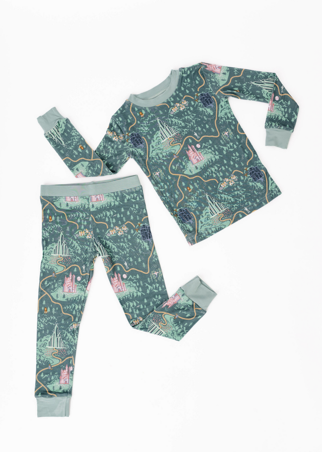 Wizard of Oz inspired pajamas on a deep green background featuring the Emerald City, Yellow Brick Road, and Wizard of Oz characters.