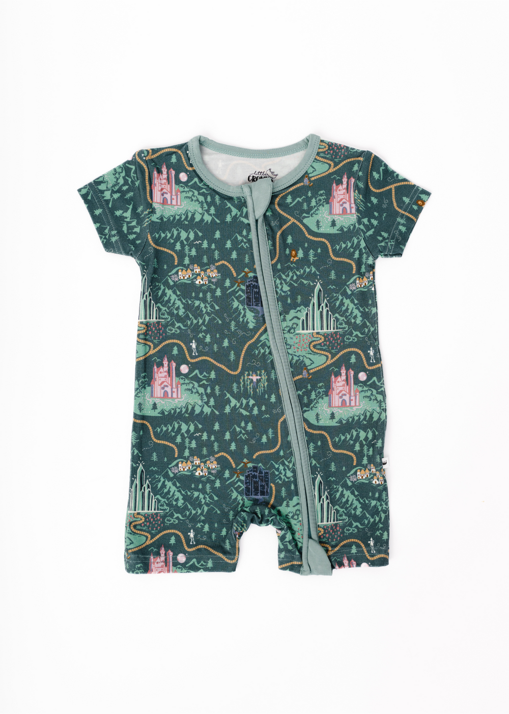 A shortie romper with a hand-drawn map design featuring castles and landscapes, predominantly in green tones, with a central zipper. Wizard of Oz inspired design with a yellow brick road and characters.