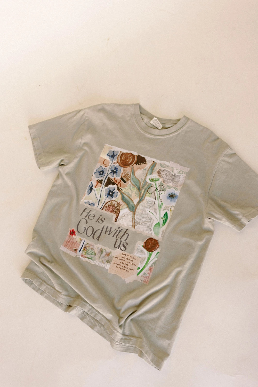Light green t-shirt with floral design and text on a beige background